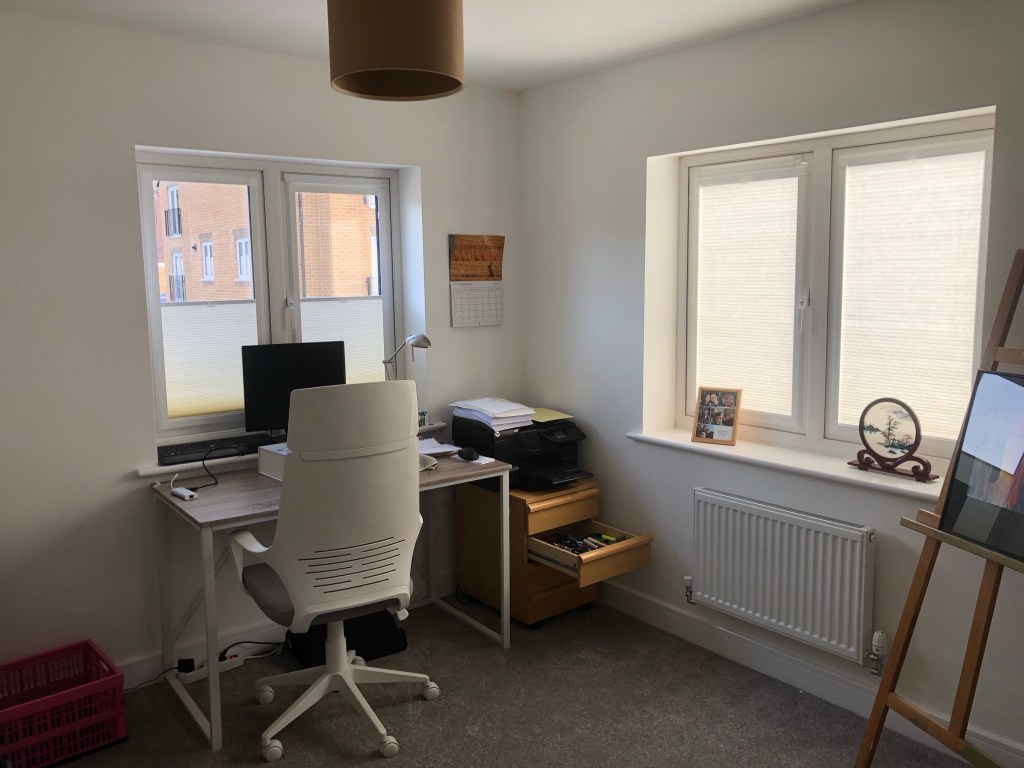 Light filtering honeycomb blinds fitted in home office with white perfect fit frames 